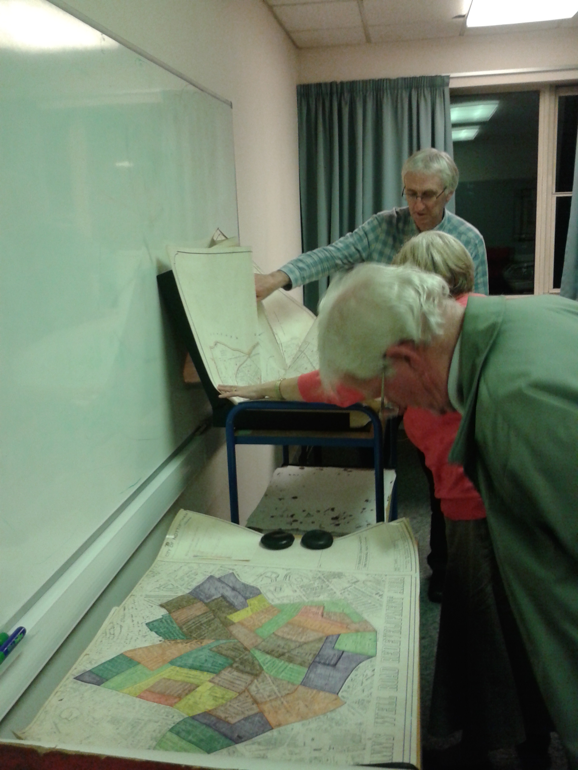 People look at a brightly coloured map on a table