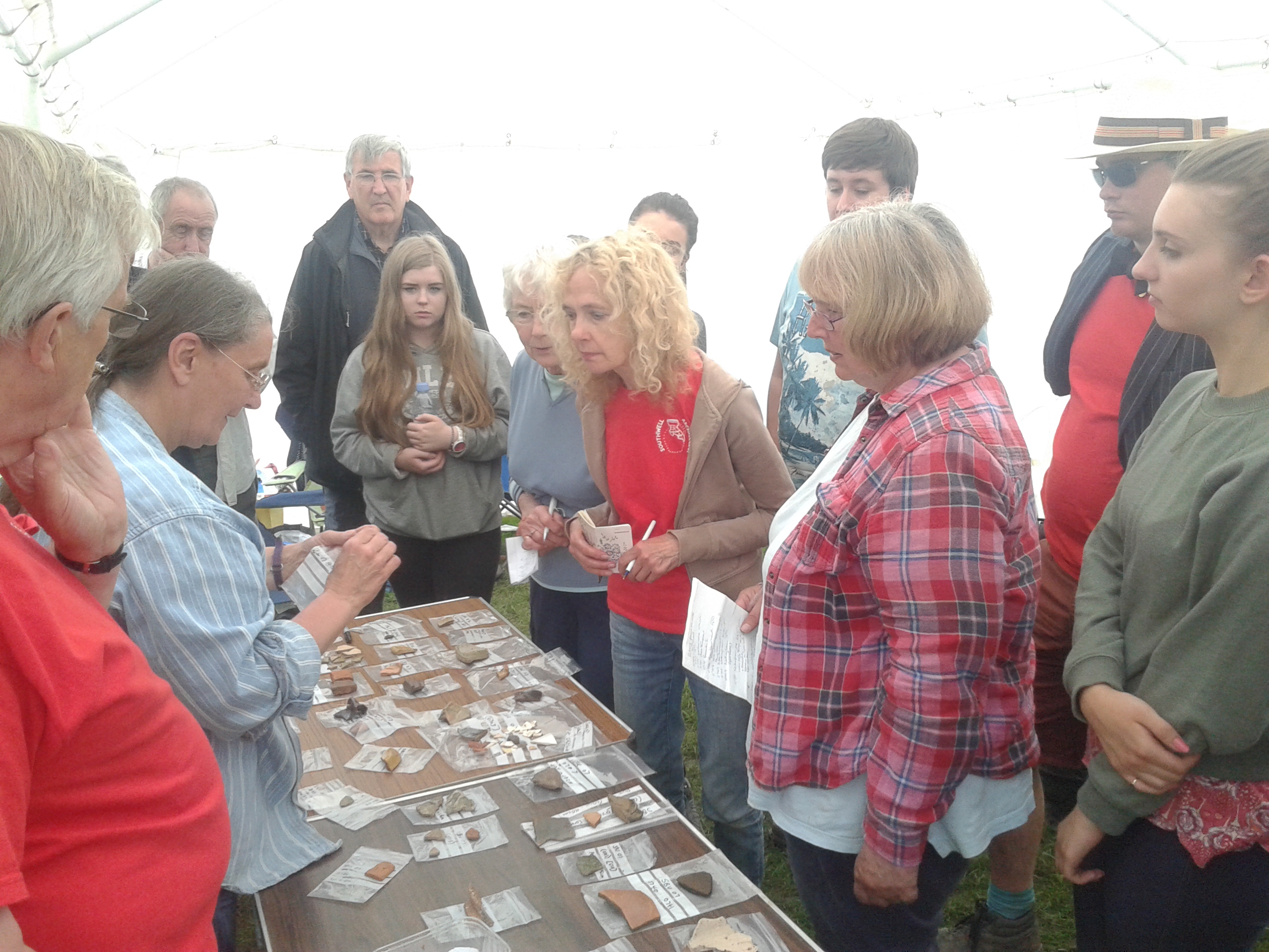 A group of people look at some archaeological finds from Southwell