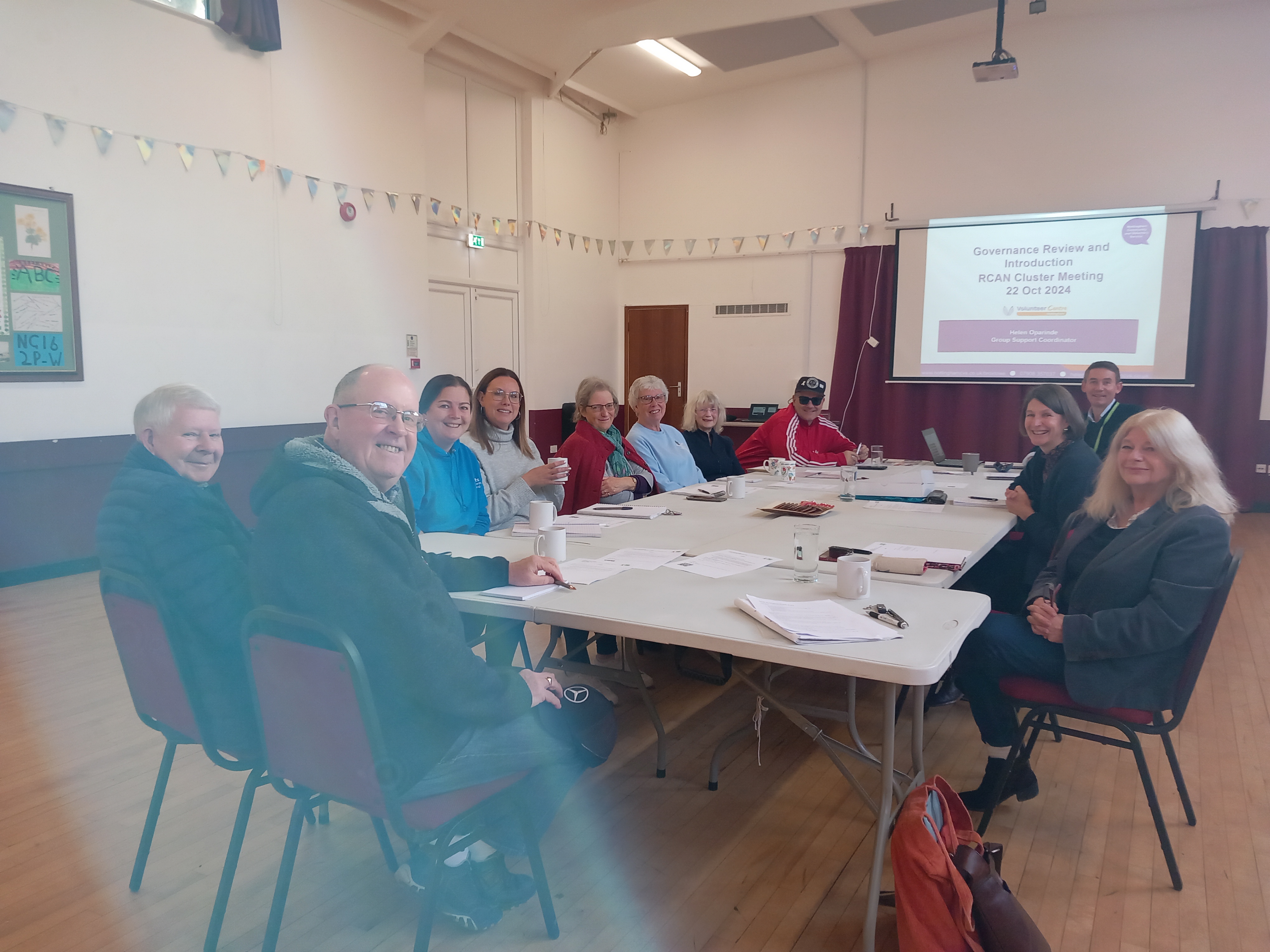 People sat at a table at the cluster meeting