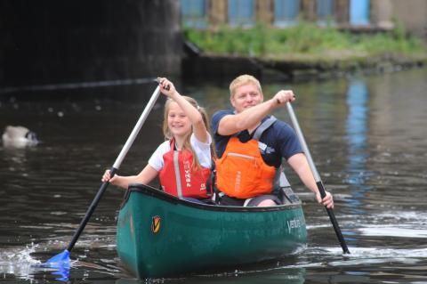 Two people canoeing on a river